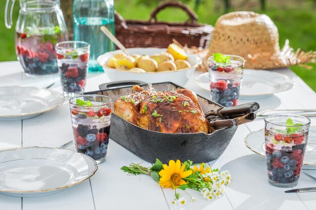 Cena casera con patatas y pollo servido en mesa blanca