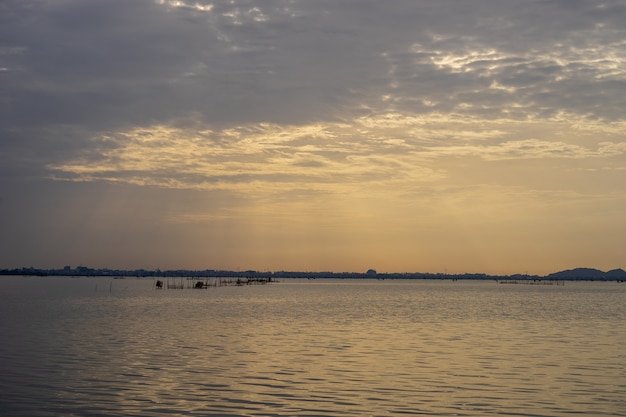 Cena da manhã do lago Songkhla, Tailândia do sul com as gaiolas dos peixes no meio.