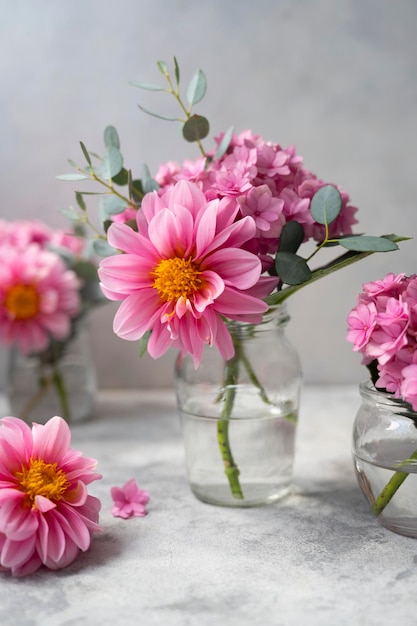 Cena de flores rosa de vida morta Flores de hortênsia rosa e dálias em vaso de vidro em fundo neutro foco seletivo suave