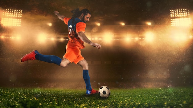 Cena de futebol à noite com jogador de uniforme laranja chutando a bola com força