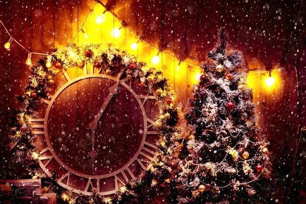 Cena de Natal com presentes de árvore e fogo no fundo. Antigo relógio de rua grande na parede do edifício. Ano novo, conceito de férias