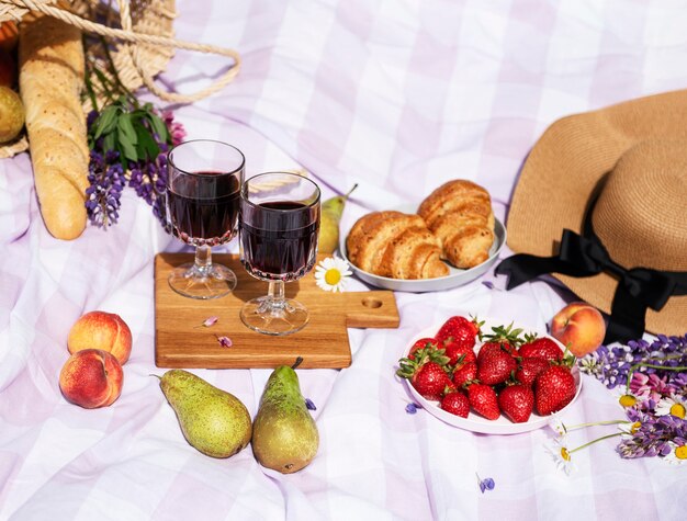 Cena de piquenique romântico num dia de verão. piquenique ao ar livre com vinho e uma fruta ao ar livre no fundo da grama verde.