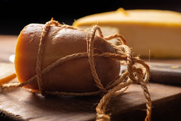 Cena de queijos com diferentes queijos e acessórios sobre foco seletivo de madeira rústica