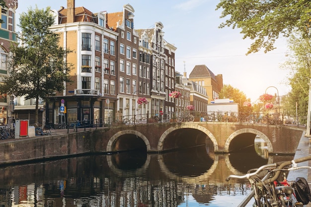 Foto cena do canal da ponte no pôr do sol amsterdã, holanda