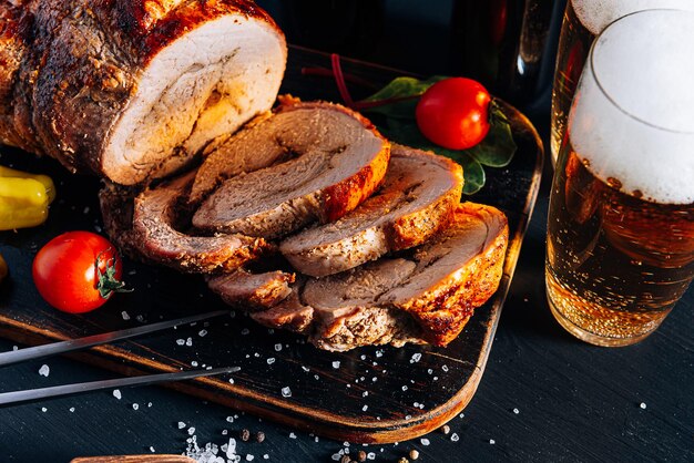 Cena para dos de carne y cerveza artesanal dos vasos de cerveza carne picada al horno con verduras en una bandeja de madera con tenedor de carne y especias