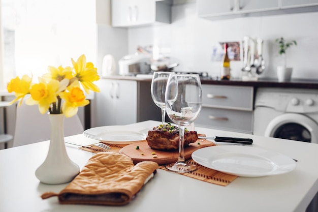 Cena para dos servida en la cocina cocina moderna diseño carne asada en el fondo de la cocina