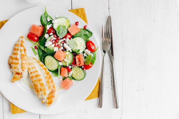 Cena con ensalada y pollo en plato