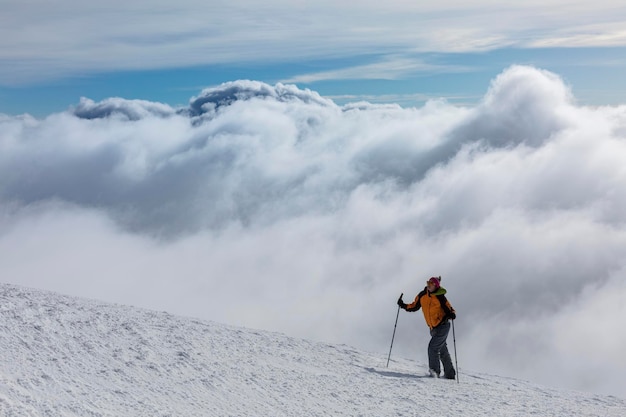 Cena épica de mulher no cume da montanha como símbolo de sucesso na vida Silhueta de homem turista em pé no topo Incrível vista panorâmica do cume da montanha coberta de neve