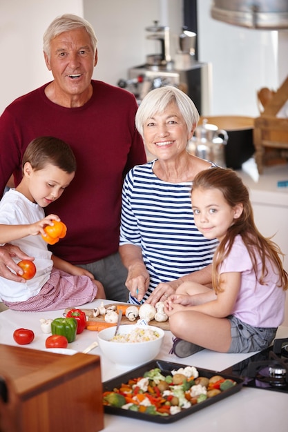 La cena estará lista en poco tiempo Retrato de unos abuelos preparando una comida con sus nietos