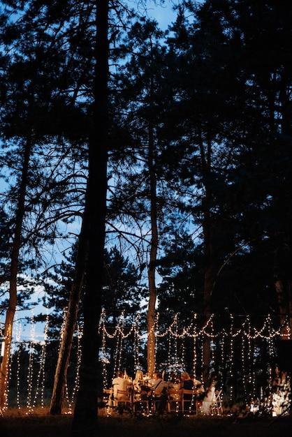 Cena familiar de boda por la noche en el bosque.