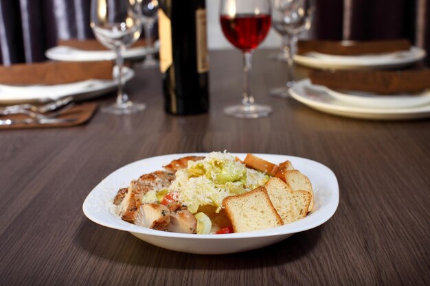 Cena de lujo servida en la mesa con una copa de vino tinto