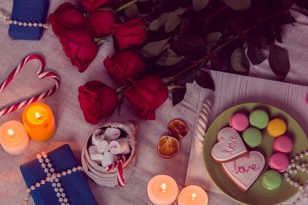 Cena a la luz de las velas con rosas rojas y regalos