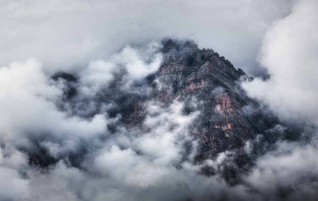 Cena majestosa com montanhas nas nuvens na noite nublada