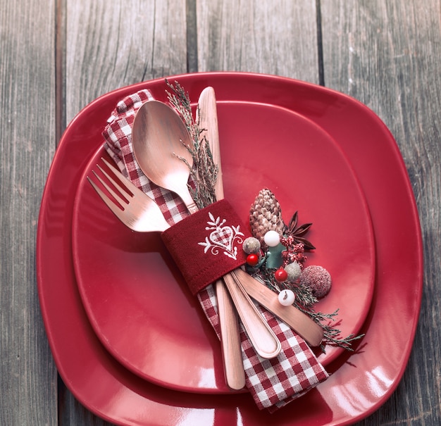 Cena de Navidad cubiertos con decoración en una mesa de madera