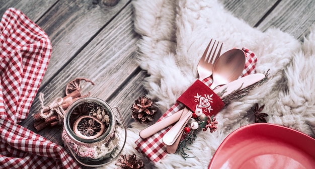 Cena de Navidad cubiertos con decoración en una mesa de madera