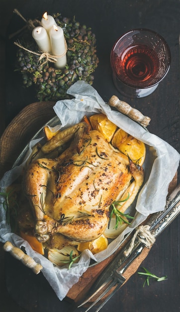 Cena navideña con velas decorativas de pollo entero asado y vino