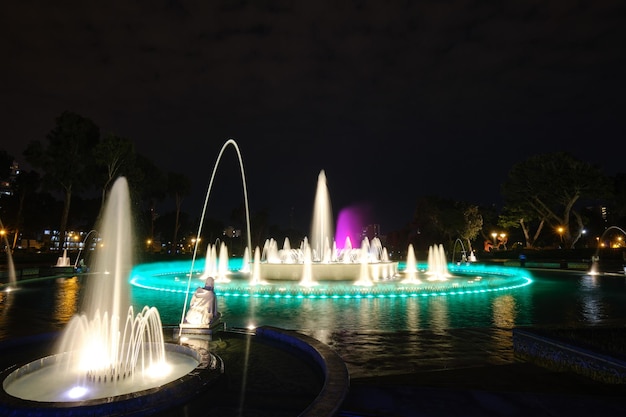 Cena noturna de cachoeiras nas piscinas do circuito mágico de águas no parque recreativo de Lima, popular pelas cores coloridas de suas águas
