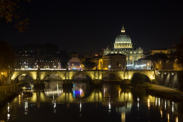 Cena noturna do rio roma tevere com basílica ao fundo