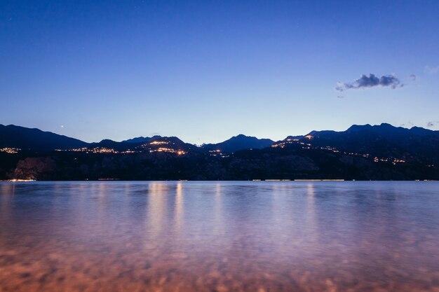 Cena noturna em lago di garda Lake rocks and village