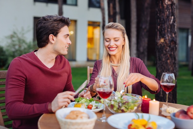 Cena en restaurante. Feliz pareja encantada sentados juntos en el restaurante mientras disfruta de su comida