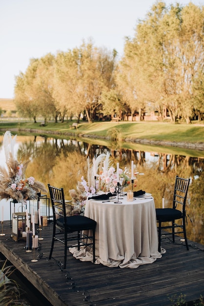 Cena romántica para dos junto al lago al atardecer.