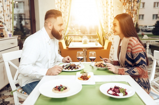 Cena romántica felices hombres y mujeres en restaurante.