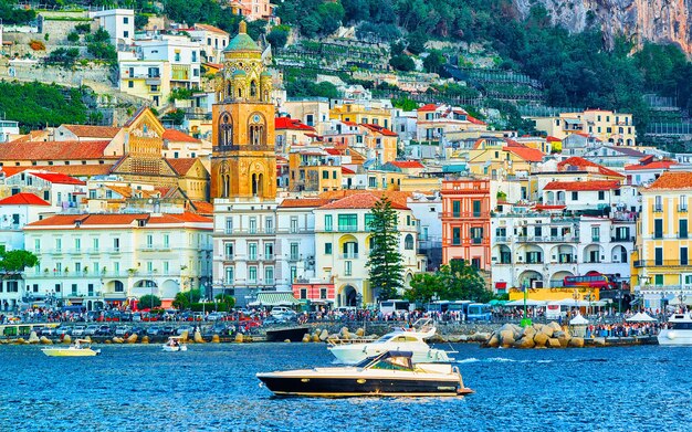 Cenário com iate na cidade da costa de Amalfi no mar Tirreno no outono. Litoral de Amalfitana na Itália. Verão italiano com belas águas azuis. Vista panorâmica. Feriado e férias. Paisagem.