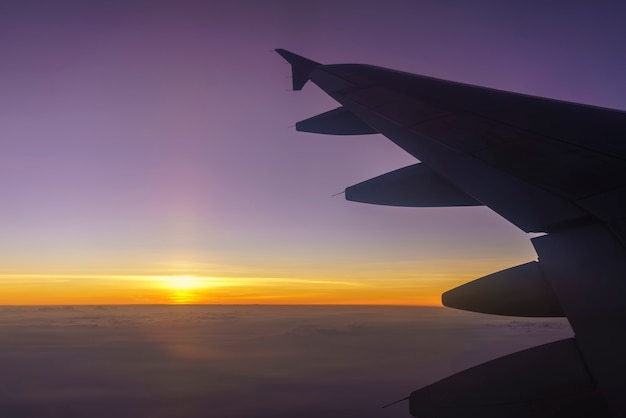 Foto cenário da janela do avião com vista da asa do avião e belo pôr do sol