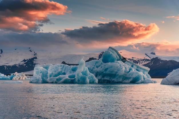 Cenário da lagoa glacial de Jokulsarlon com derretimento de iceberg azul e céu pôr do sol no verão