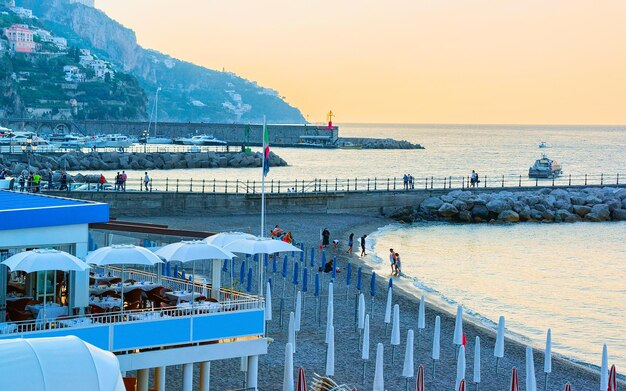 Cenário de café e praia na cidade da costa de Amalfi, no mar Tirreno, no outono. Restaurante com mesa e cadeiras no litoral de Amalfitana na Itália. Verão italiano com água azul. Feriado e férias