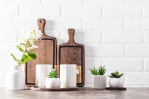 Foto cenário de cozinha elegante com tábuas de corte de madeira escura e lindas canecas modernas vista frontal itens ecológicos