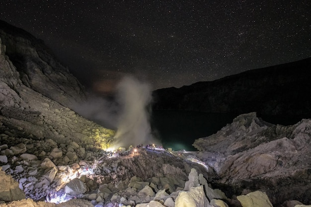 Cenário de cratera com fumaça de enxofre com chama azul à noite