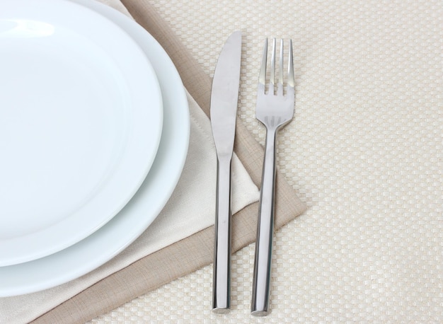 Cenário de mesa com pratos de faca de garfo e guardanapo