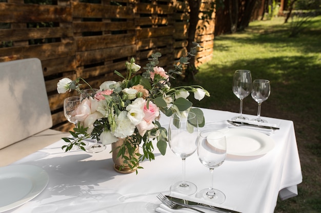 Cenário de mesa de casamento decorado com flores frescas em um vaso de latão