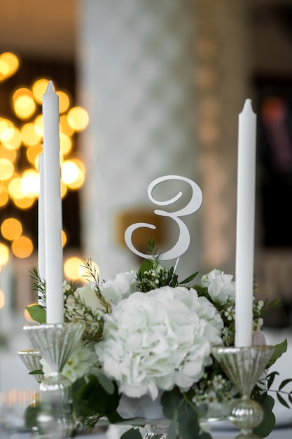 Cenário de mesa de casamento é decorado com flores frescas e velas brancas