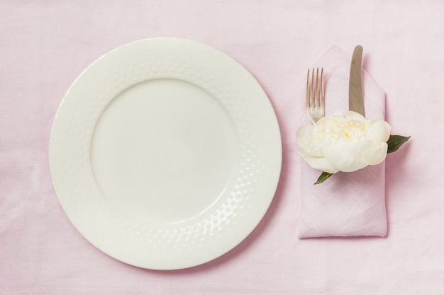 Cenário de mesa de elegância com planta na toalha de mesa de linho rosa