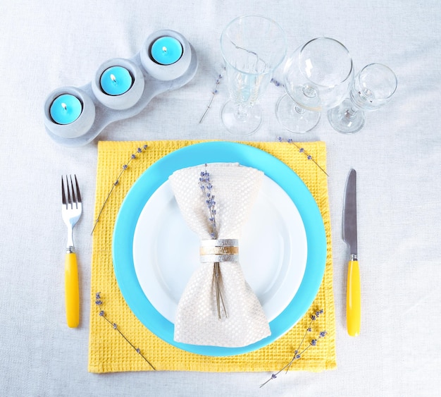 Cenário de mesa de jantar com flores de lavanda em um fundo claro de toalha de mesa