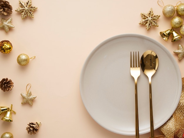 Cenário de mesa de jantar de natal com enfeites de ouro