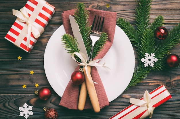 Cenário de mesa de natal com decoração de natal e pratos kine garfo e colher fundo de férias de natal vista superior