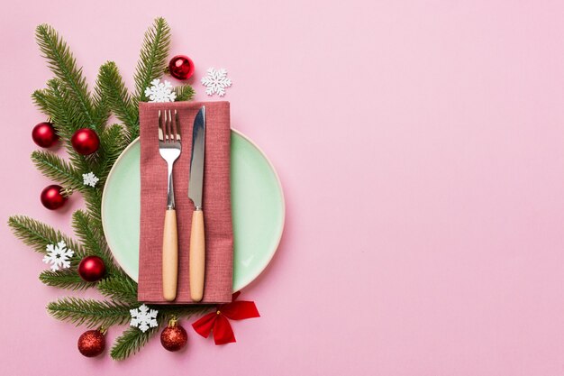 Cenário de mesa de Natal com decoração de Natal e pratos, vacas, garfo e colher. Fundo de férias de Natal. Vista superior com espaço de cópia