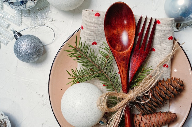 Cenário de mesa de Natal com prato de decoração talheres rústicos de madeira para um jantar festivo
