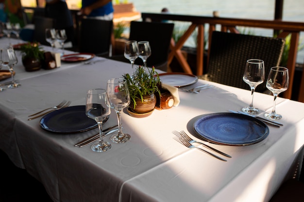 Cenário de mesa elegante em um restaurante ao ar livre.