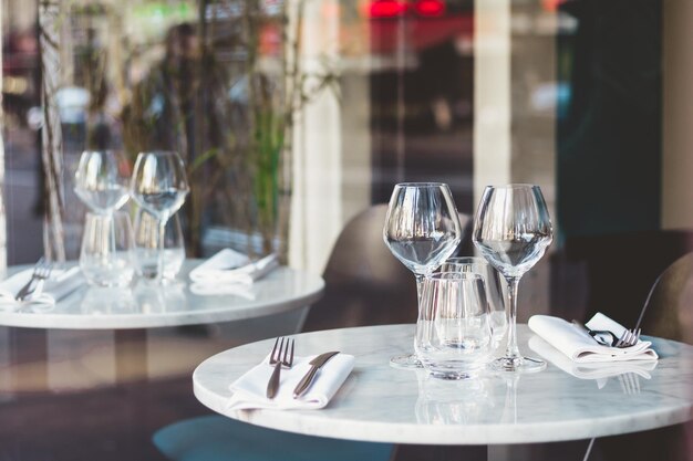 Cenário de mesa em um restaurante francês para dois Vista através de uma janela de uma rua