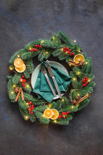 Cenário de mesa festiva com enfeites de natal em forma de uma guirlanda de natal