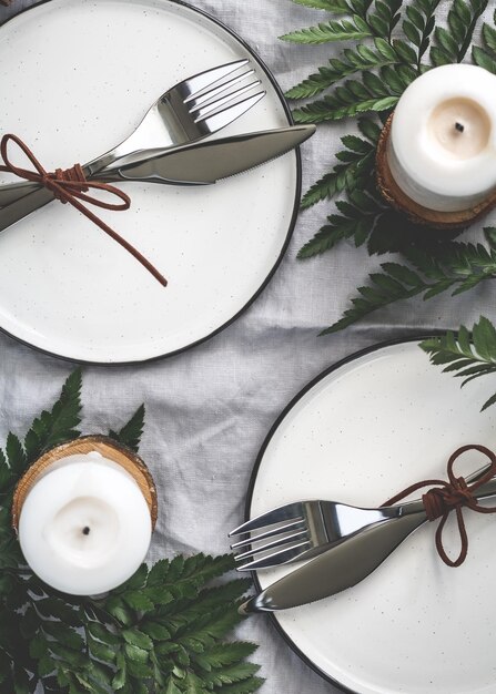 Cenário de mesa festivo entre decorações de inverno e velas brancas Vista superior plana O conceito de um jantar em família de Natal ou Ação de Graças