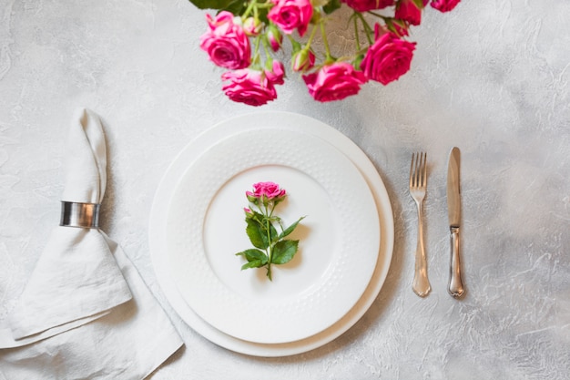 Cenário de mesa romântica com buquê de rosas e decorações. Vista do topo.