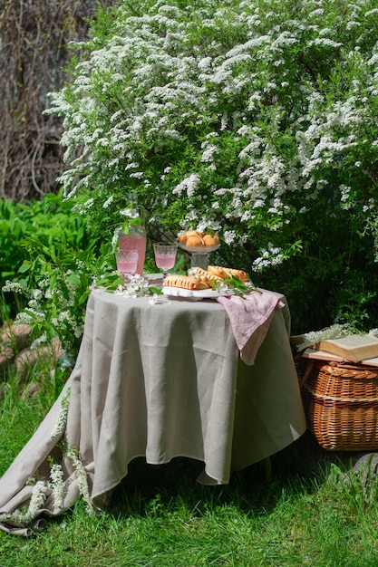 Cenário de mesa romântica de primavera festiva com sobremesa no conceito de mesa romântica de jardim florido vertical