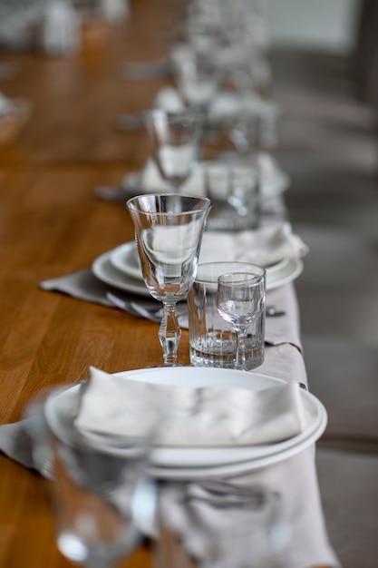 Cenário de mesa romântico festivo com guardanapo cinza talheres e louça branca na toalha de mesa de seda bege