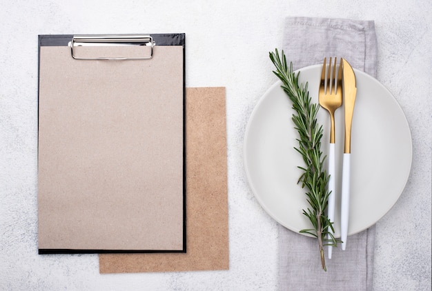 Cenário de mesa vista superior com prancheta e legumes