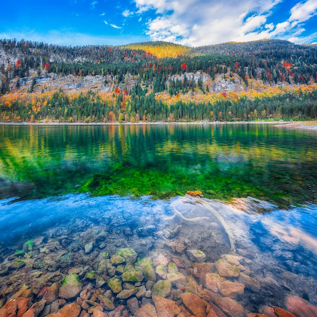 Cenário de outono com cume da montanha Dachstein refletindo no lago cristalino da montanha Gosausee